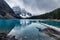 Man traveler sitting on timber in Moraine Lake on gloomy day at Banff national park