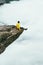 Man traveler sitting on Trolltunga rocky cliff edge