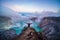 Man traveler standing on edge of crater Ijen volcano with colorful sky at morning