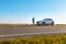 man traveler standing near car at roadside of speedway at sunset