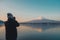 Man traveler standing and taking photo Beautiful Mount Fuji with snow capped in the morning sunrise at Lake kawaguchiko, Japan.