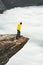 Man traveler standing on Trolltunga rocky cliff edge