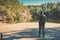 Man traveler standing on a wooden deck on the shore of the lake