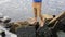 Man traveler stands on the edge of a waterfall extreme