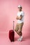 Man traveler with suitcase, passport and ticket on color background.