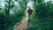 Man traveler walks along a path through a mountain forest. Travel lifestyle