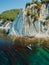 Man traveling on stand up paddle board in sea. Surfer walking on SUP board in sea with scenic landscape. Aerial view