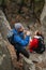 Man trekker drinking water from bottle on rocks