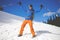 Man with trekking poles goes through the snow in the mountains.