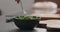 Man tries fresh salad with radish, cucumber and herbs in black bowl