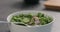 Man tries fresh salad with radish, cucumber and herbs in white bowl