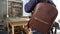 A man tries on a handmade leather backpack. Choosing a comfortable backpack for everyday use. Leather interior