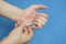 A man trims his fingernails using a metallic pair of nail clippers