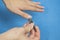A man trims his fingernails using a metallic pair of nail clippers