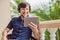 man in tropics talking with friends and family on video call using a tablet and wireless headphones