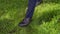 Man in trousers and brown boot walking on grass close up