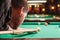 Man trying to hit the ball in billiard.