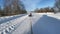 man on a tubing rushes along a country road in winter