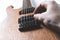 A man is tuning and adjusting a new electric guitar using measuring instruments