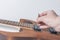 A man is tuning and adjusting a new electric guitar using measuring instruments