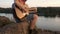 man tuning guitar outdoor. tune acoustic guitar