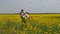 A man is turning a child. Dad turns his daughter in yellow. A happy family. Rapeseed field.