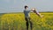 A man is turning a child. Dad turns his daughter in yellow. A happy family. Rapeseed field.