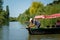 Man turning on a motor boat engine at river or lake among green trees. Contryside summer landscape, leisure fishing