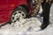 The man turns up shovel wheel of a car with snow drifts.