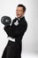 Man in tuxedo holds dumbell.