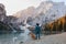 man with a two dogs at the famous mountain lake Braies in Italy. Traveling with a pet