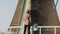 Man with two kids stand by old Dutch windmill. Single father with daughter and son look at a huge mill. Back view. 4K.