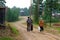 A man and two women Asian Yakuts with packages from picking mushrooms are on the Northern road in the village of Yakutia