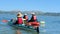 Man and two women kayaking in calm water