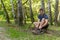 Man tying his shoelaces in the park outdoors, around the forest, oak trees green grass young enduring athletic athlete