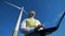 A man types on a laptop near an electric windmill, standing on a field. Alternative energy concept.