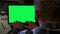 Man typing on laptop keyboard with green screen chroma key while sitting in home office. Young man uses computer for