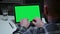 Man typing on laptop keyboard with green screen chroma key while sitting in home office. Young man uses computer for