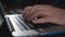 Man typing on laptop keyboard in the office. Close up man hands writing on laptop computer keyboard.