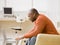 Man typing on laptop in livingroom