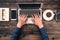 Man typing laptop on wooden desk