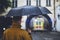 Man with umbrella looking at leaving ambulance car