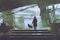 Man with umbrella stands under building in rainy day