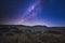 Man under a beautiful night in the desert under the light of the stars