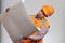 Man in uniform examines with interest opened paper project on grey studio background. Funny construction worker in protective