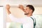 Man in uniform installing roller window blind