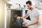 Man unloading dishwasher and enjoying in housework.