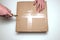 Man unpacking box with cutter. View from above. The concept of delivery and verification of online purchases or opening a gift