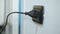 Man unplugging electronic device in wall power plug socket at home,energy cost saving
