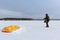 Man unwinding slings near a kite in the snow, Ob reservoir, Novosibirsk, Russia